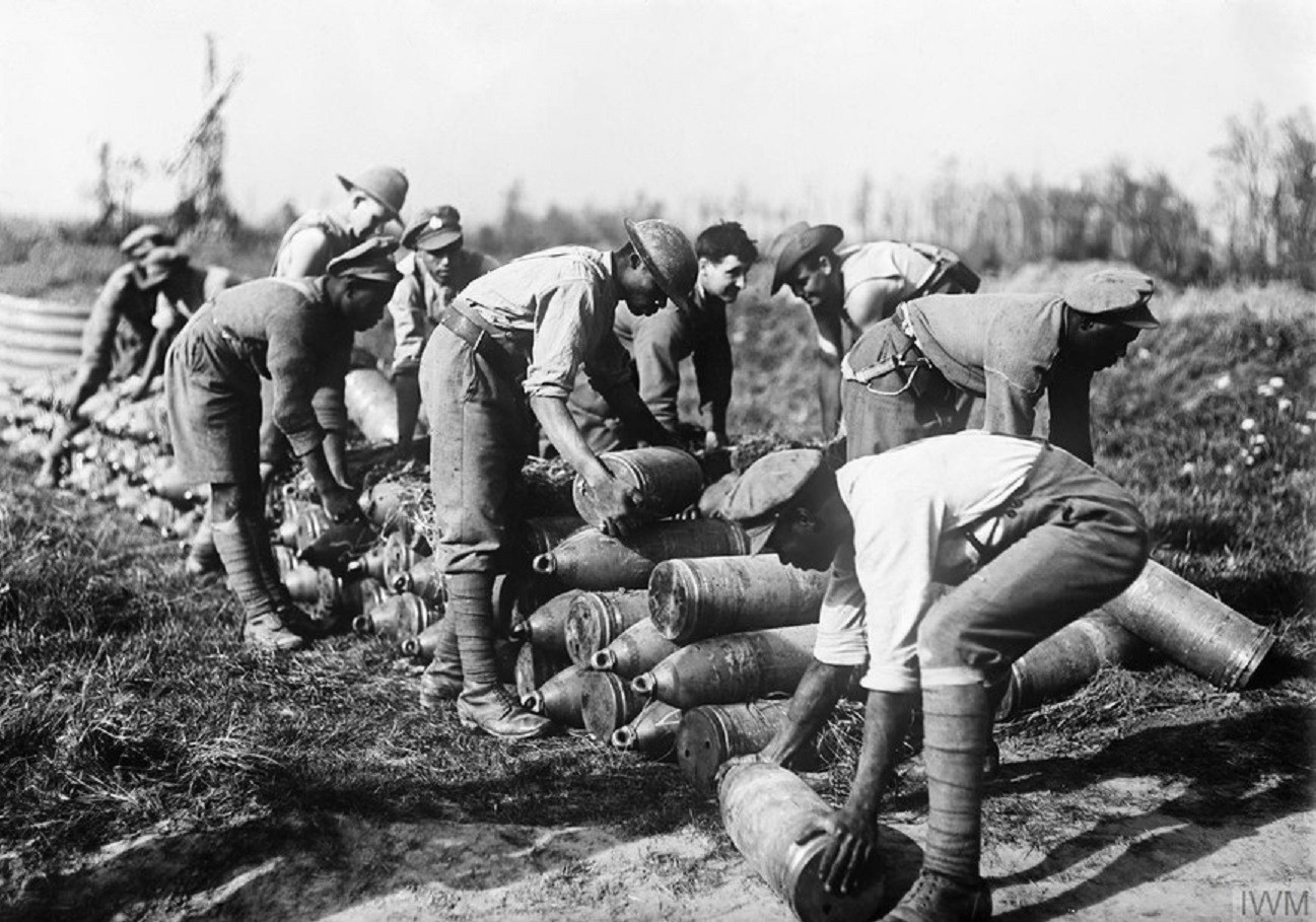 Black and white photograph showing troops of the BWIR stacking artillery shells in a field