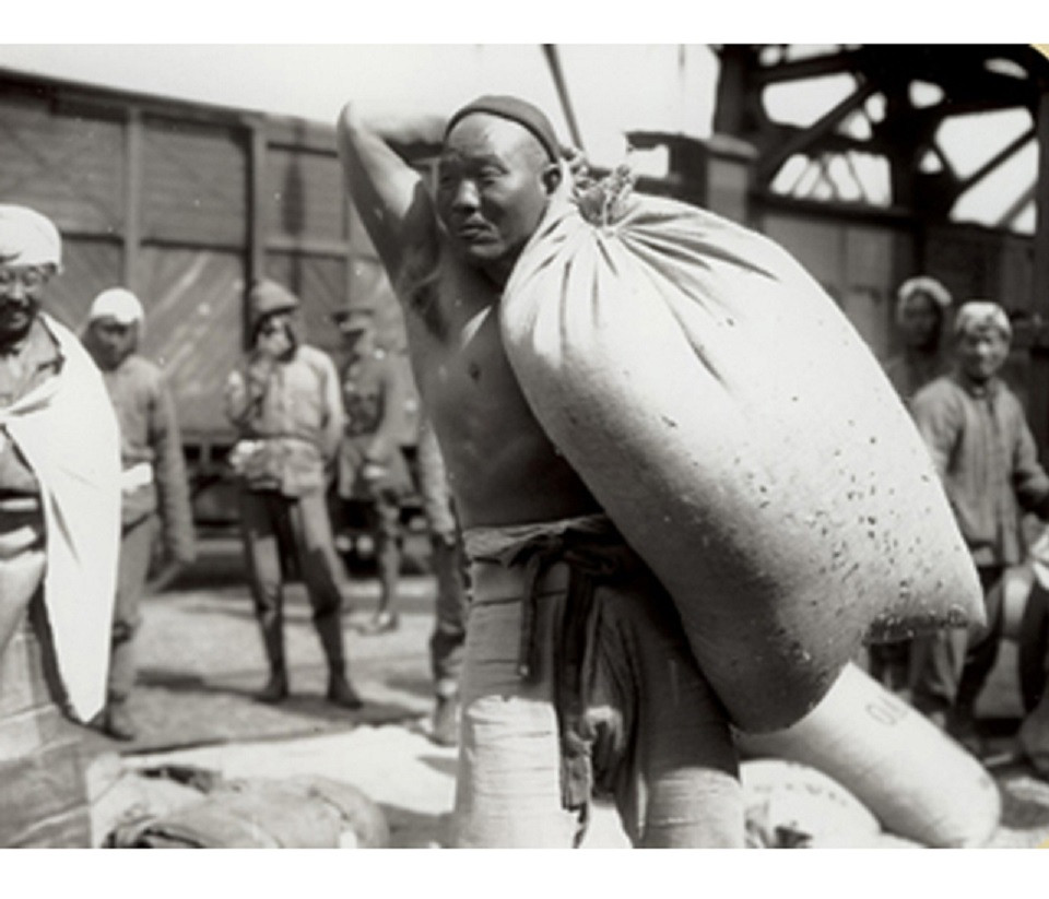 Black and white photograph showing a Chinese worker