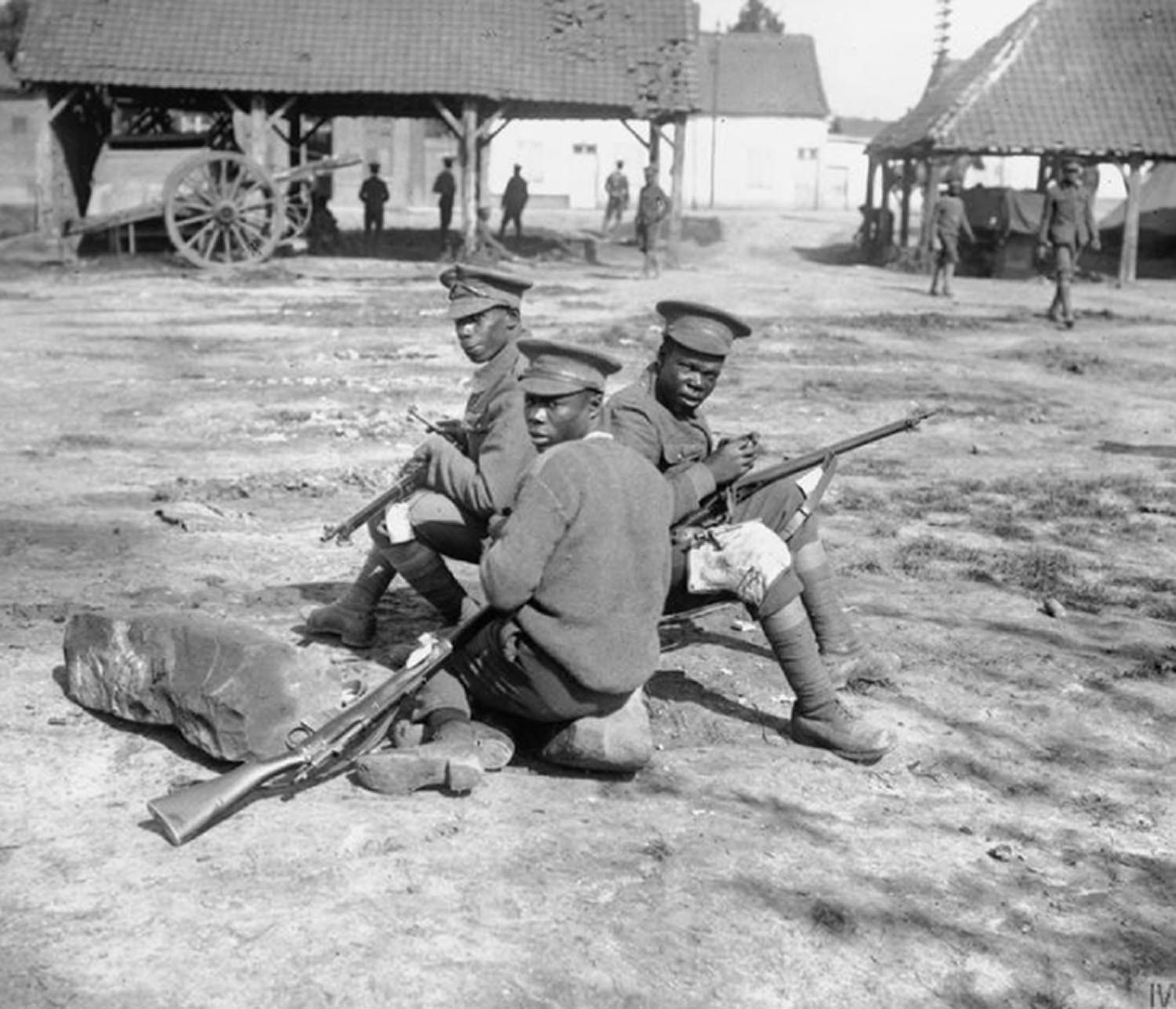 Black and white photograph showing three privates of the BWIR at rest with their weapons