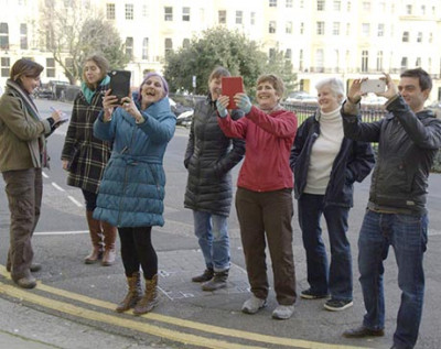 A group of volunteers gather in Brunswick Square to test VisAge on mobile devices