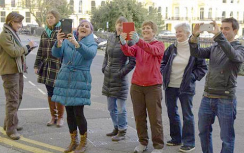 A group of volunteers in Brunswick Square, Hove, using iPads to test storytelling software